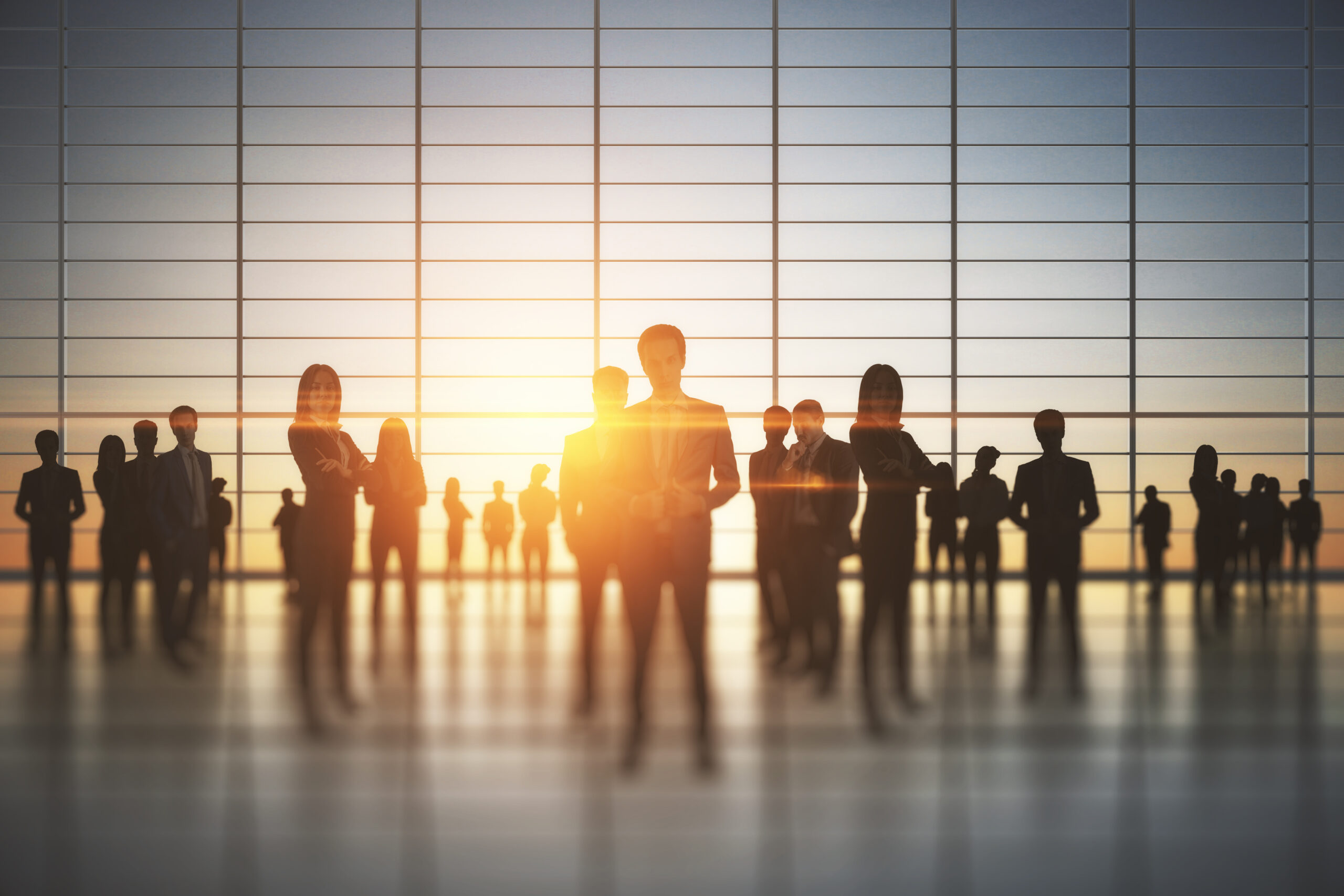 Silhouetted people in a corporate office at sunset