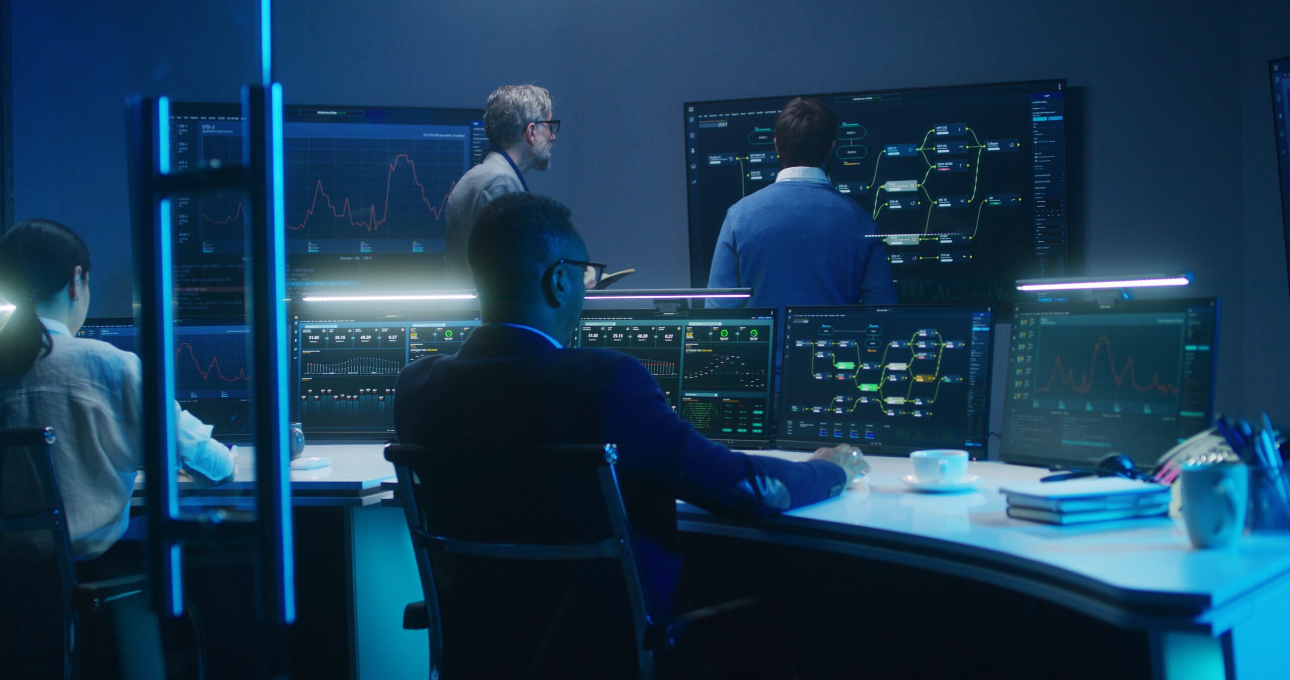Team of IT technical specialists and software programmers work in monitoring office