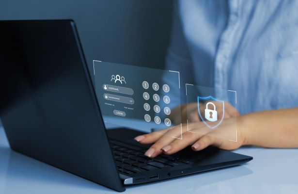 person typing on a laptop with a digital screen displayed with a login screen, number pad and padlock inside a shield displayed. It depicts email security.