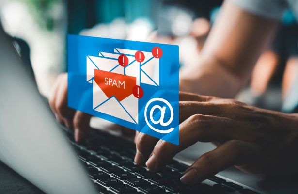 a businessman reading electronic mail with a laptop superimposed by a spam, junk mail, spam email pop-up warning