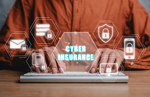 man typing on a keyboard with big icons displayed and cyber insurance displayed in the middle
