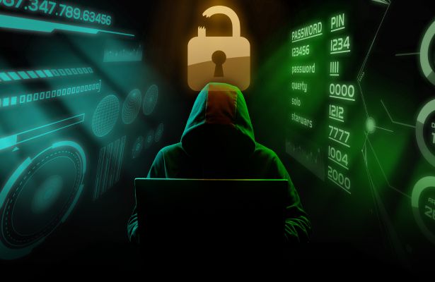 man in a hoodie, covering his face, typing on a laptop, like he is a threat actor. A giant padlock is behind him.